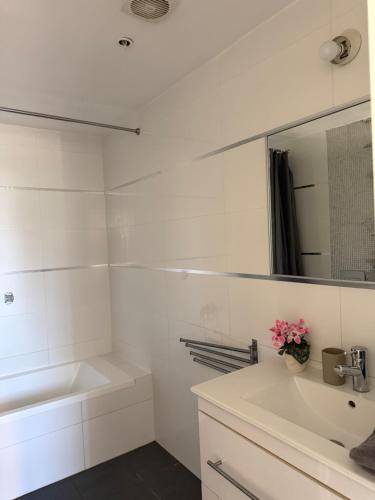 a white bathroom with a sink and a mirror at appartement privé exceptionnel in Netanya