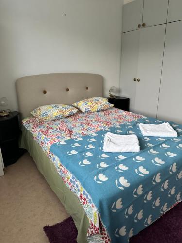 a bedroom with a bed with a blue comforter and pillows at Kätevä Koti Keskustassa in Ähtäri