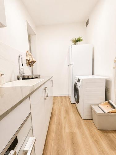 a white kitchen with a refrigerator and a sink at אמור in Beer Sheva