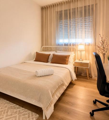 a bedroom with a bed and a chair and a window at אמור in Beer Sheva