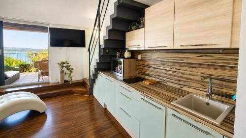 a kitchen with a counter with a sink and a window at Apartmán Pálava 1 s terasou a výhledem na jezero in Pavlov