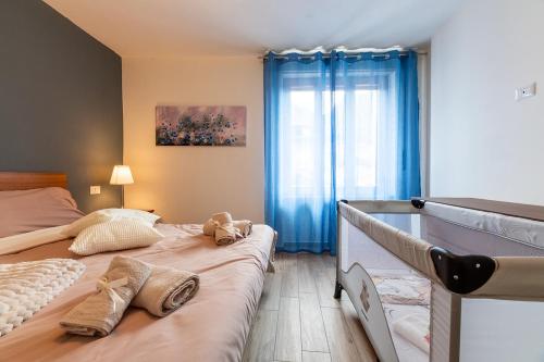 a bedroom with two beds and blue curtains at Puria Rustic Lake View Apartment in Valsolda
