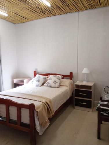 a bedroom with a bed with a wooden headboard at Hogar en el corazón de Tilcara in Tilcara