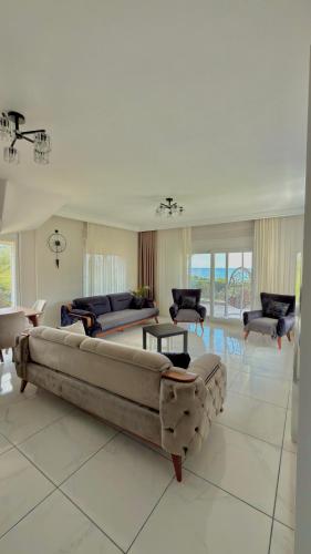 a large living room with a large couch and chairs at Platan Paradise in Maronia