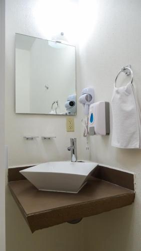 a bathroom with a white sink and a mirror at Urbania Office Hotel in Tuxtla Gutiérrez