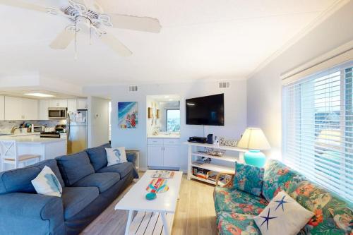 a living room with a blue couch and a table at Crystal Sands 403 in Ocean City