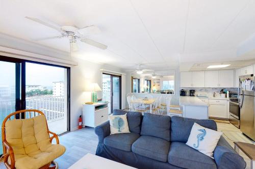 a living room with a blue couch and a kitchen at Crystal Sands 403 in Ocean City