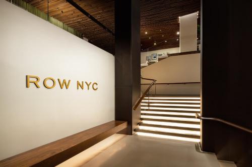 a stairway with a row ivc sign on a wall at ROW NYC at Times Square in New York