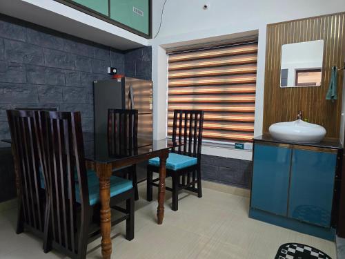 a dining room with a table and chairs and a sink at River Portico in Tenmalai