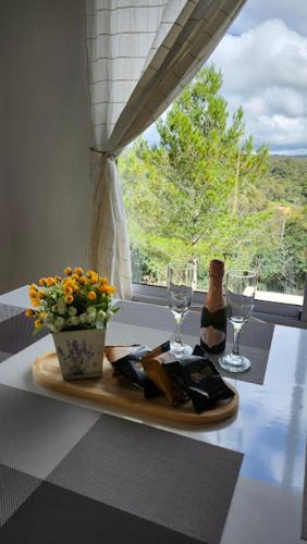 a table with a bottle of wine and two glasses at Cabañas Elementos in Huerta Grande