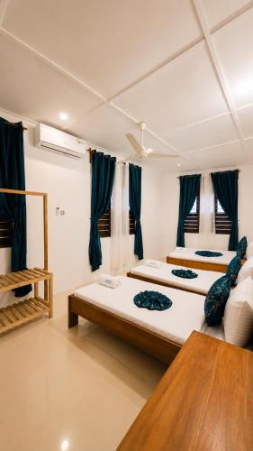 two beds in a room with blue curtains at Serene Abodes in Zanzibar City