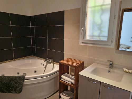 a bathroom with a bath tub and a sink at Chambre privative in Lecci