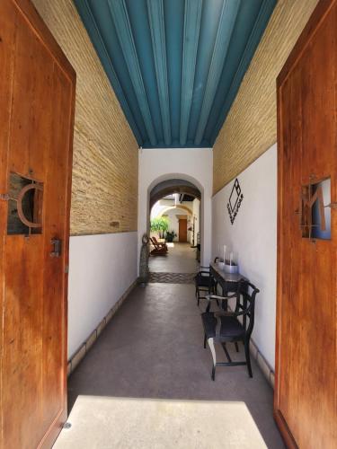 a hallway with a table and chairs and a blue ceiling at CAMASanlúcar in Sanlúcar de Barrameda