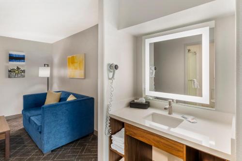 a bathroom with a sink and a blue chair at Comfort Inn & Suites Ogallala in Ogallala