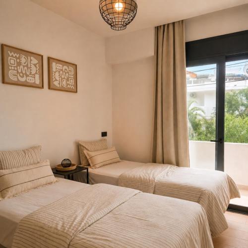 two beds in a room with a window at Xenia Residence in Faliraki