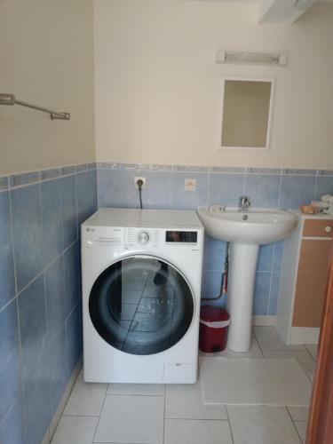 a washing machine in a bathroom with a sink at La maison d'Arthur et Armelène in Rely