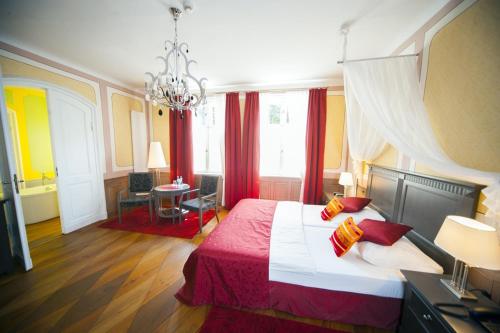 a bedroom with a large bed and a chandelier at Hotel zum Hofmaler in Potsdam