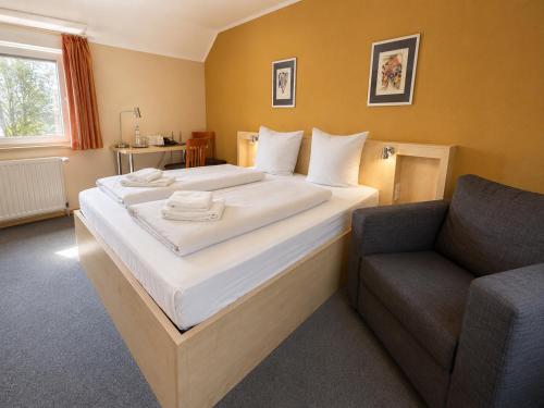 ein Hotelzimmer mit zwei Betten und einem Stuhl in der Unterkunft WOS Hotel in Mönchengladbach