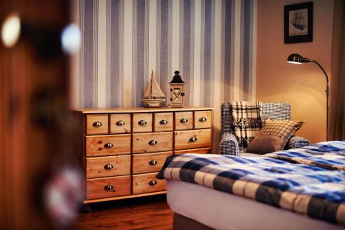 a bedroom with a dresser next to a bed at Ostoja Dwa Jeziora in Węgorzewo