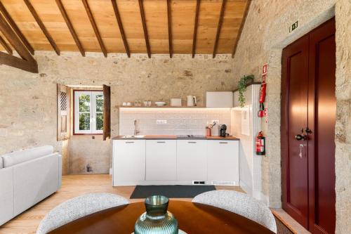 a kitchen with a table and chairs and a counter at RioVerde Agroturismo in Barcelos