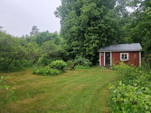 a small red shed in the middle of a field at Villa Tuomiranta in Porvoo