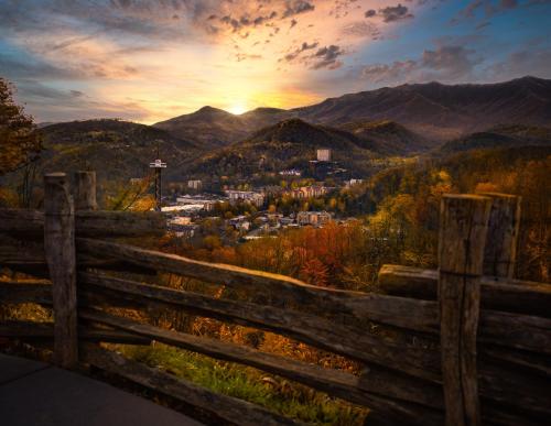 a view of a town from a fence with the sunset at By The Night in Pigeon Forge
