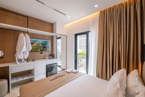a bedroom with a white bed and a window at Aura Mare Hotel in Ksamil