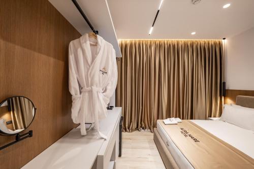 a bedroom with a white robe hanging on a wall at Aura Mare Hotel in Ksamil