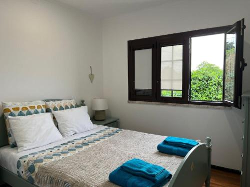 a bedroom with a bed with two blue towels on it at Rustic Villa with Private Pool near Ericeira in Mafra