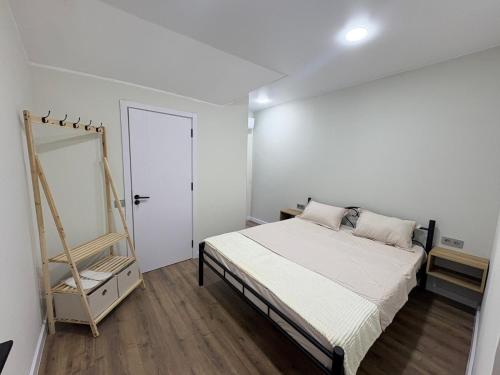 a white bedroom with a bed and a mirror at EmiLiza in Kobuleti