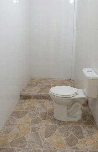 a bathroom with a toilet sitting on a tiled floor at Cabaña Villa Samantha in Buenaventura