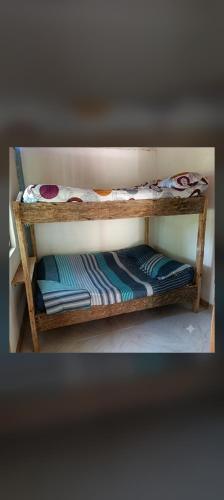 two wooden bunk beds with blankets and pillows on them at Cabaña Villa Samantha in Buenaventura