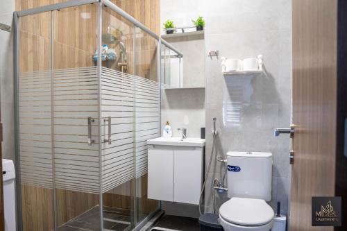 a bathroom with a shower and a toilet and a sink at M2 Apartments in Štip