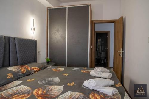 a bedroom with a bed with towels on it at M2 Apartments in Štip