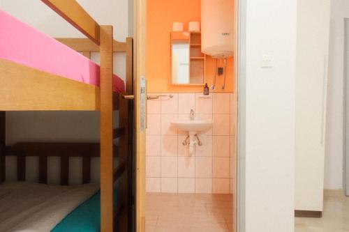 a bathroom with a sink and a bunk bed at Lantana ex Villa Americana in Karlobag