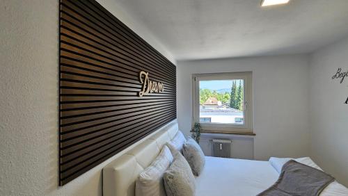 a bedroom with a bed with a large wooden headboard at Feel Home Apartment in Dornbirn
