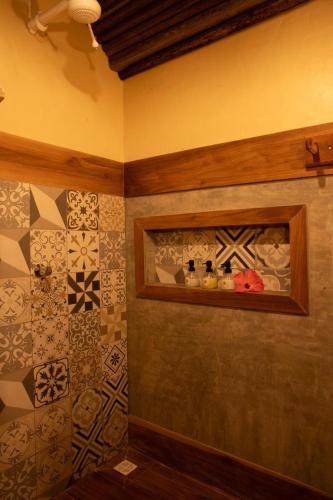 a bathroom with a shelf with bottles on it at Quinta dos Laranjais Chalés in Viçosa do Ceará