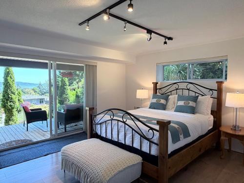 a bedroom with a large bed and a balcony at Cozy Ocean View Retreat in Victoria