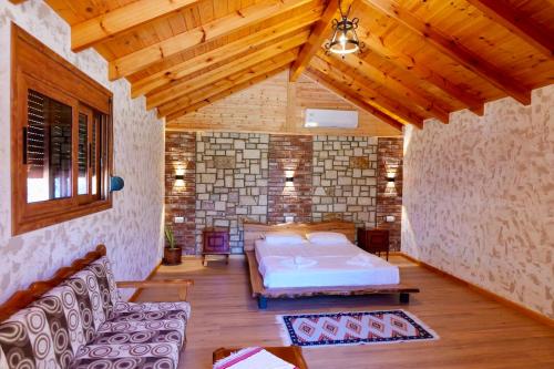 a bedroom with a bed and a couch in a room at Bujtinat e Delvinës in Delvinë