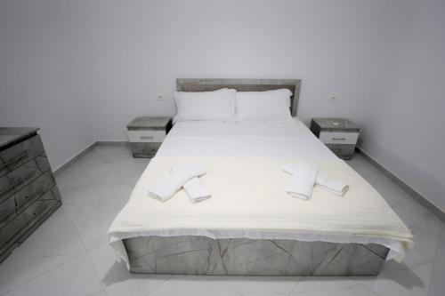 a bedroom with a bed with slippers on it at Vila Lian Apartaments in Belsh