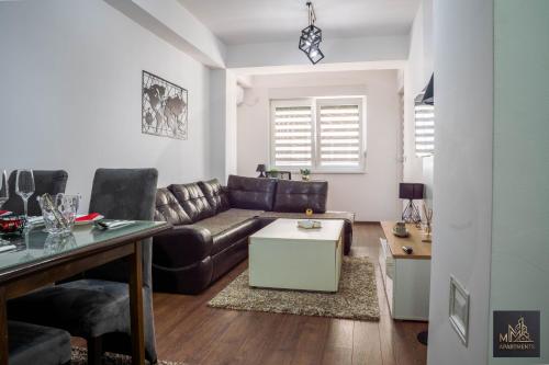 a living room with a couch and a table at М Apartments Shtip in Štip