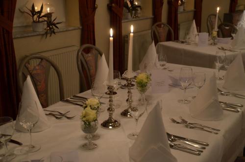 a dining table with white table cloth and flowers on it at Castell Hotel & Restaurant in Leinsweiler