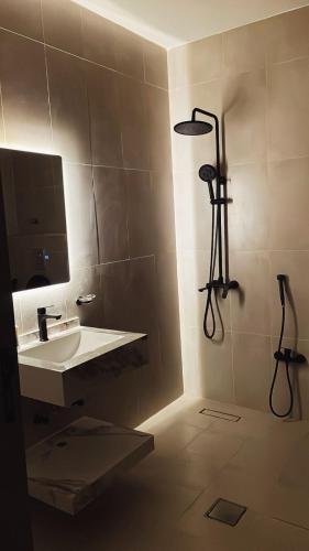 a bathroom with a sink and a shower at شاليه لوسيندا 2 in Baljurashi