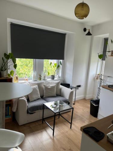 a living room with a couch and a large window at The Nook Dunblane in Dunblane