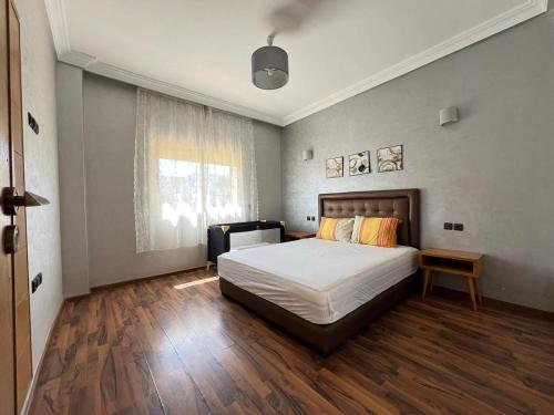 a bedroom with a bed and a large window at Villa Marina à Savannah Beach sidi rahal in Sidi Rahal