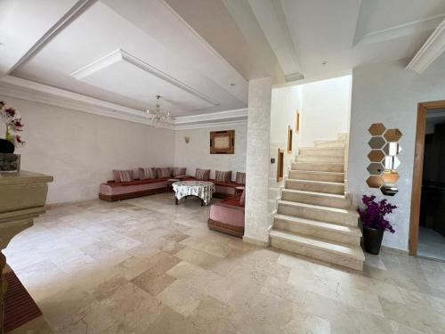 a large living room with a couch and stairs at Villa Marina à Savannah Beach sidi rahal in Sidi Rahal