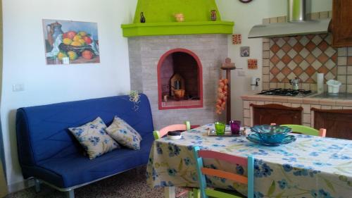 a living room with a table and a blue couch at Villetta Dote in Casarano