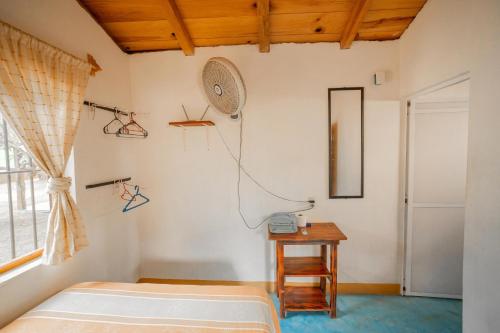 a bedroom with a bed and a table and a fan at Casa Mahue in Puerto Escondido