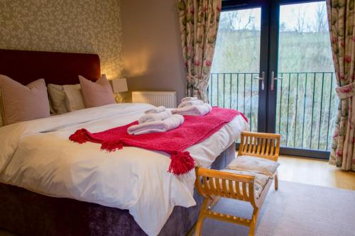 a bedroom with a bed with towels on a red blanket at Snowdrop Lodge in Errol