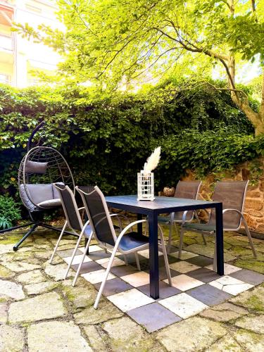 a black table and chairs sitting on a patio at Ferienwohnung Paulick I Zentrales Altstadt Apartment I Garten Terrasse Grill I 2 Schlafzimmer in Bautzen